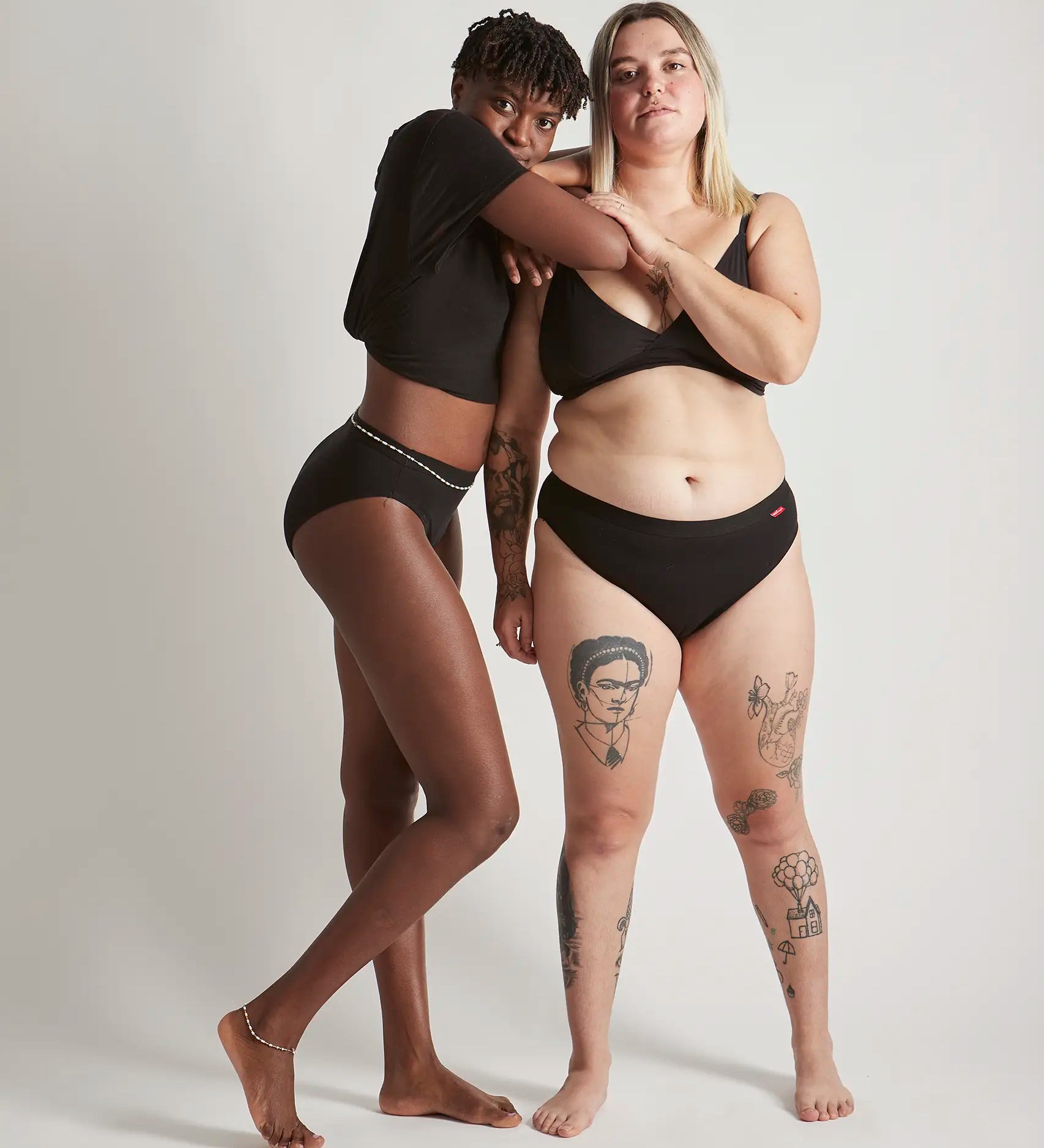 Pair of women wearing the Wuka ultimate bikini style medium flow period brief in black