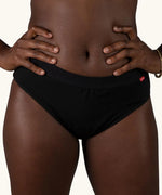 Front of woman wearing the Wuka ultimate bikini style medium flow period brief in black