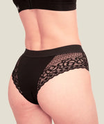 Woman wearing the Wuka ultimate lace midi medium flow period pants showing lace detail on the back
