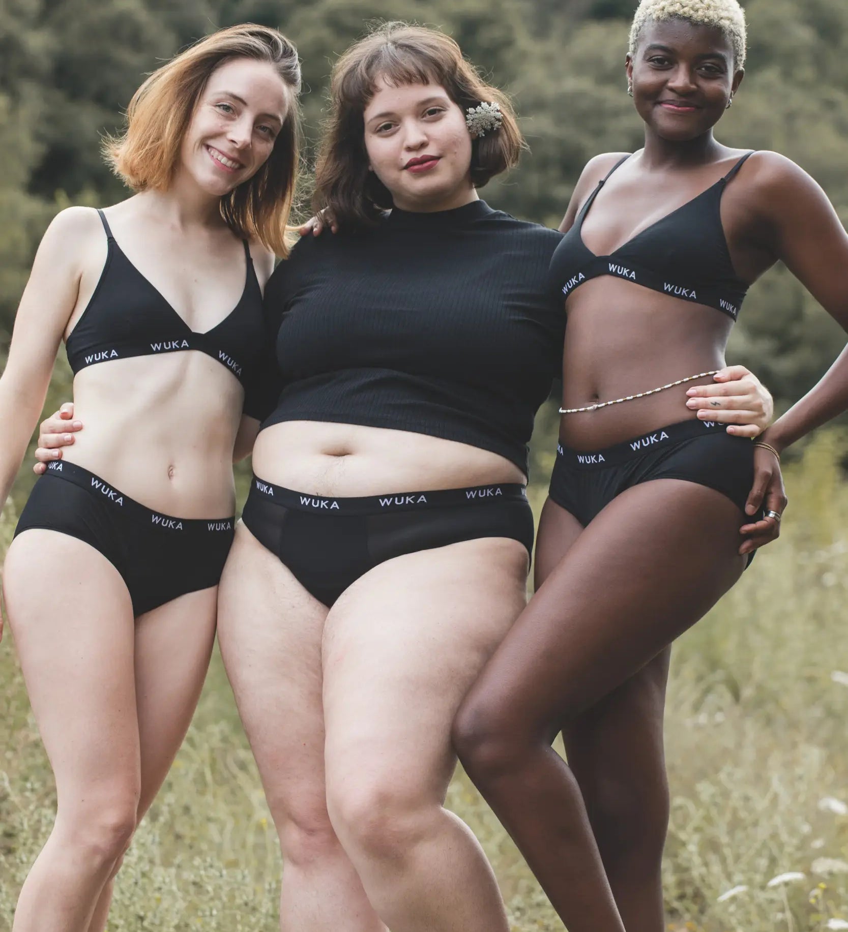 Group of women wearing the WUKA reusable ultimate midi brief period pants in a grassy field