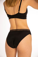 Close up of woman stood backwards on a white background wearing the eco-friendly WUKA french bikini medium flow period pants
