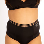 Close up of woman stood on a white background wearing the WUKA re-purpose high waisted heavy flow period pants