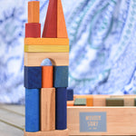 A building stack created using the blocks from the Wooden Story Rainbow XL Blocks set, the wooden storage tray can be seen in the background.