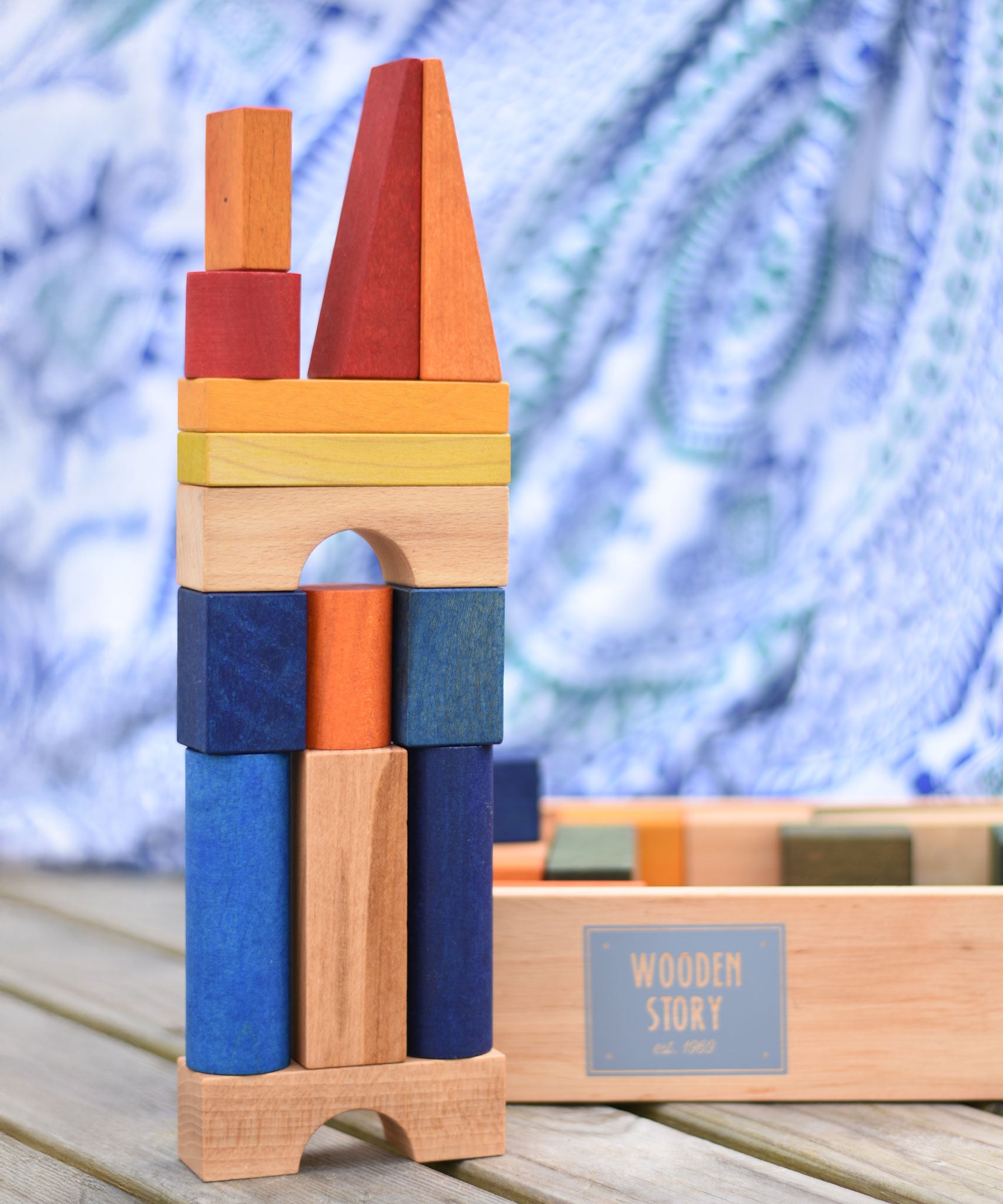 A building stack created using the blocks from the Wooden Story Rainbow XL Blocks set, the wooden storage tray can be seen in the background.