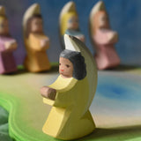 A little yellow angel wooden toy figure from Ostheimer placed on a wooden pond scene piece. This wooden figure is part of a large range of expertly hand crafted, Waldorf inspired, wooden toys here at Babipur. 