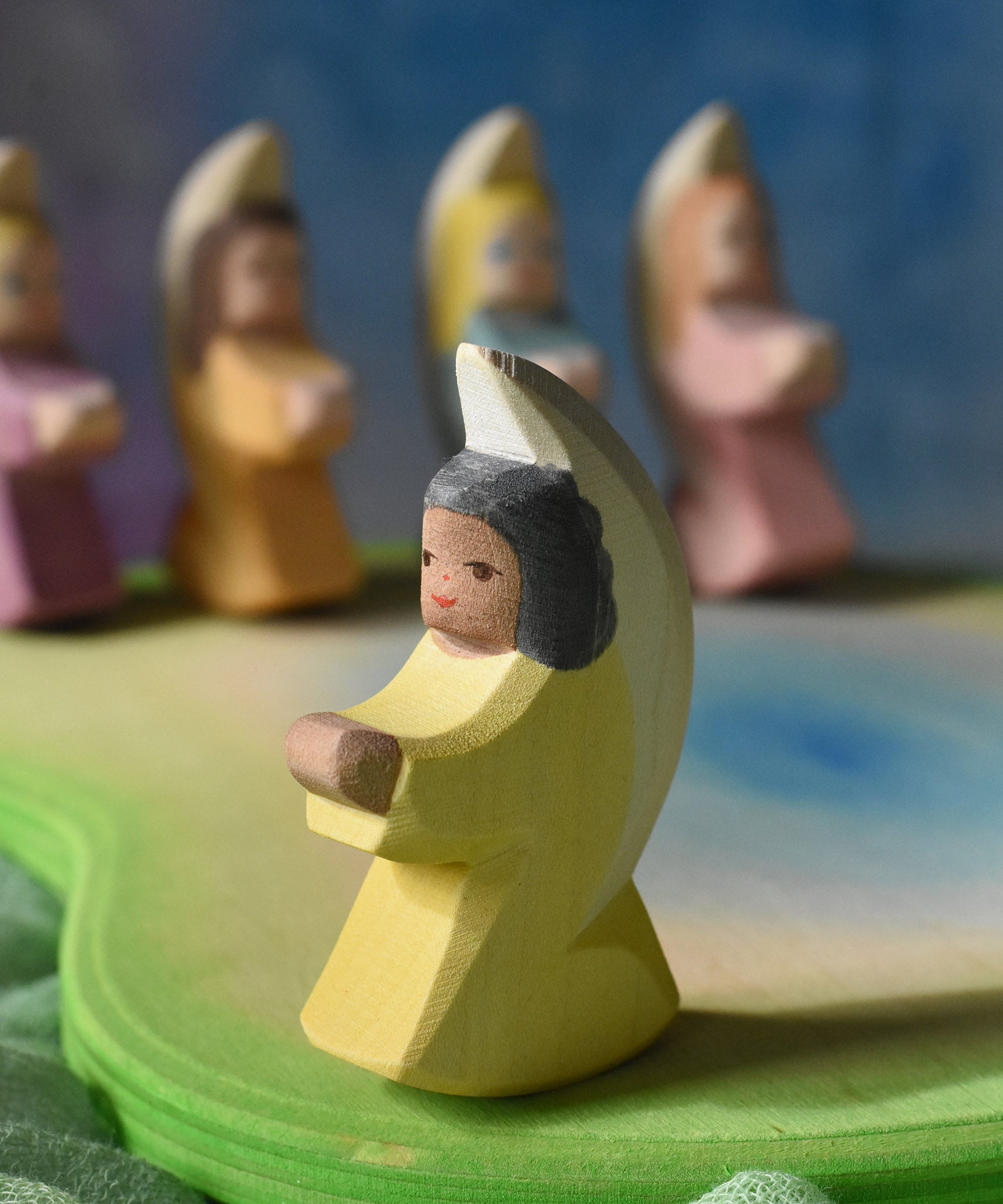 A little yellow angel wooden toy figure from Ostheimer placed on a wooden pond scene piece. This wooden figure is part of a large range of expertly hand crafted, Waldorf inspired, wooden toys here at Babipur. 