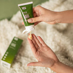 A hand squeezing the Yes oil based organic lubricant out of the tube.