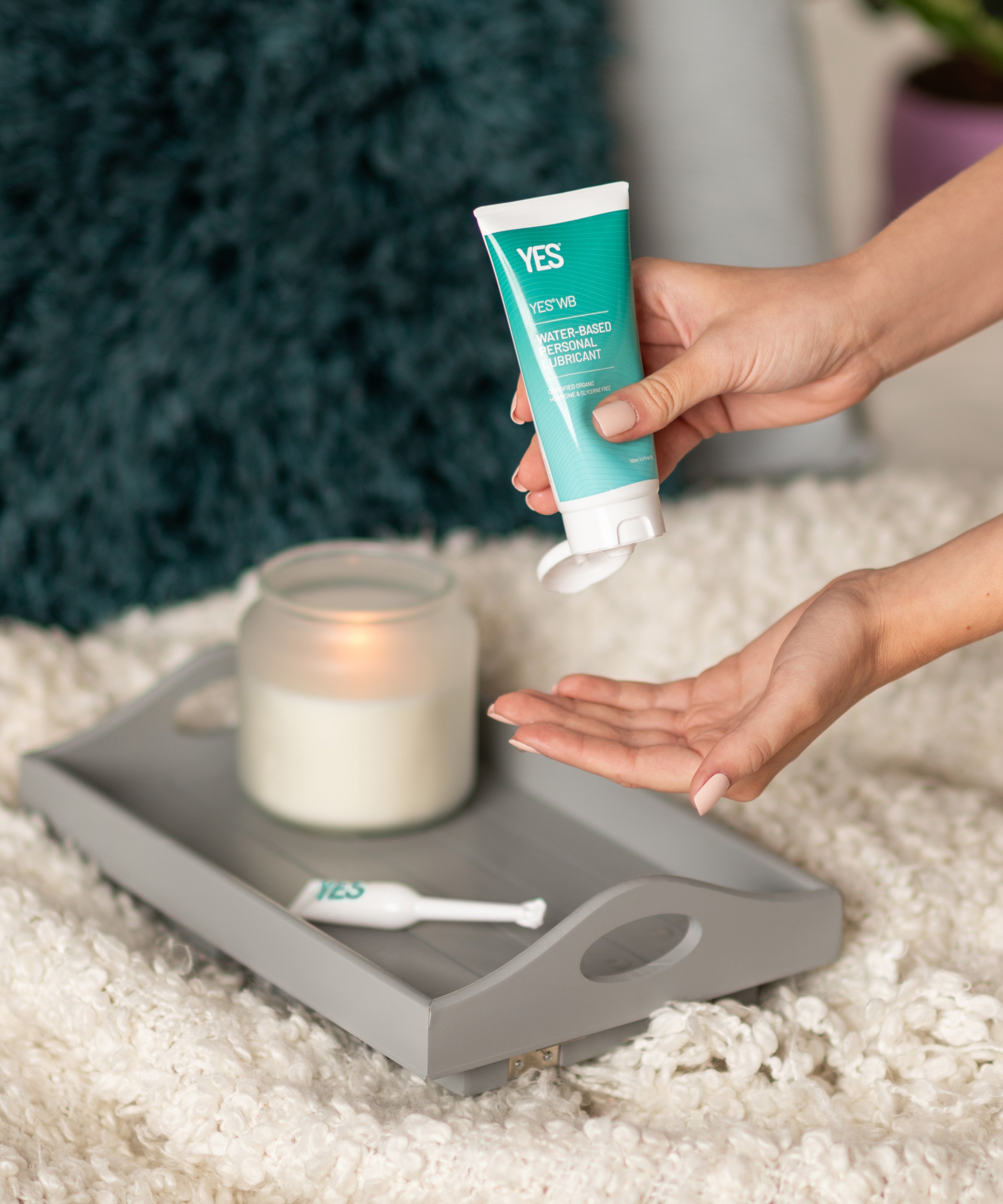 A hand squeezing some YES natural water based lubricant out of the tube.