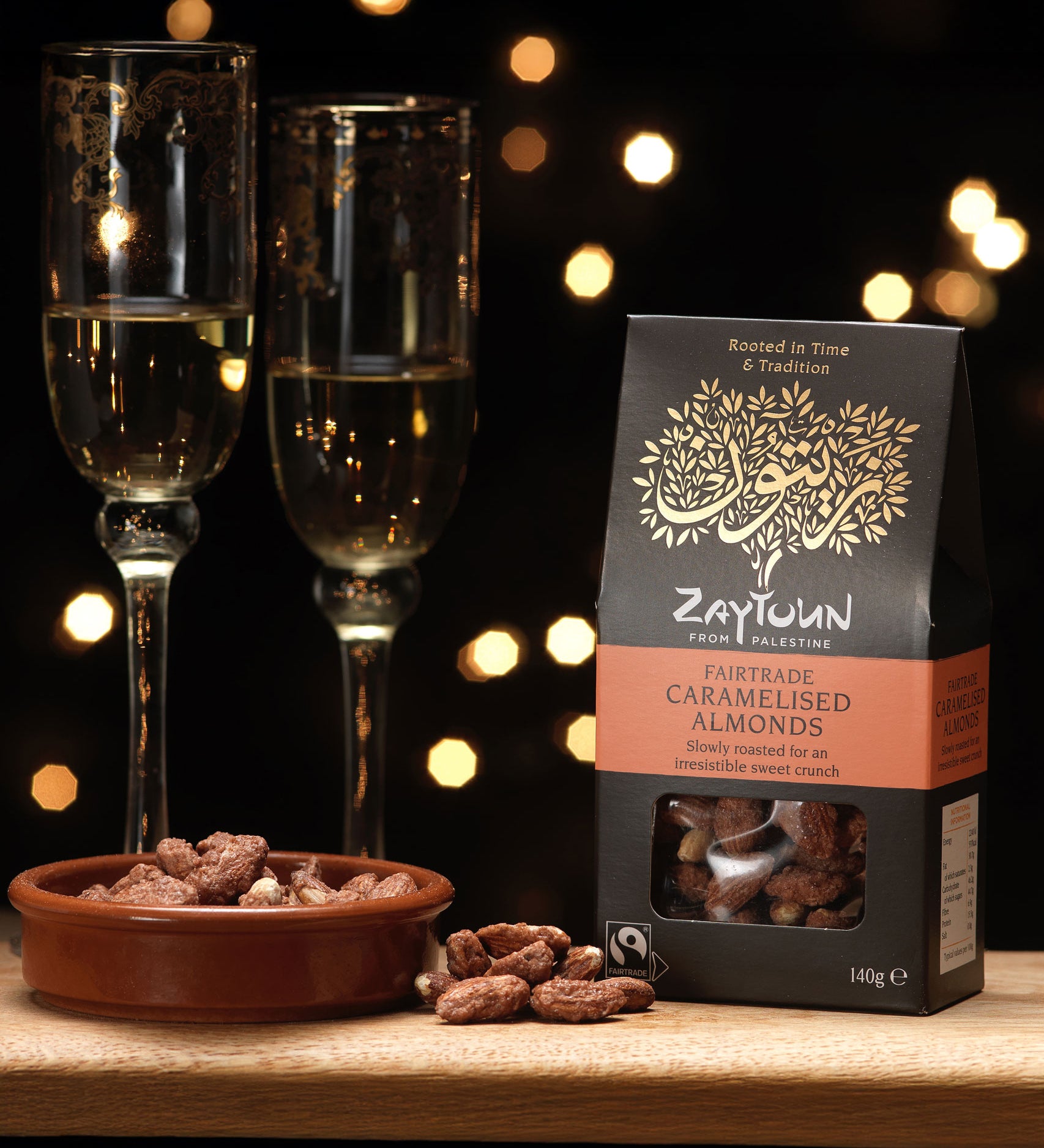 Zaytoun Fairtrade Palestinian caramelised Almonds in the box picured next to a bowl filled with the almonds. We are proud stockists of Zaytoun olive oil and produce here at Babipur. 